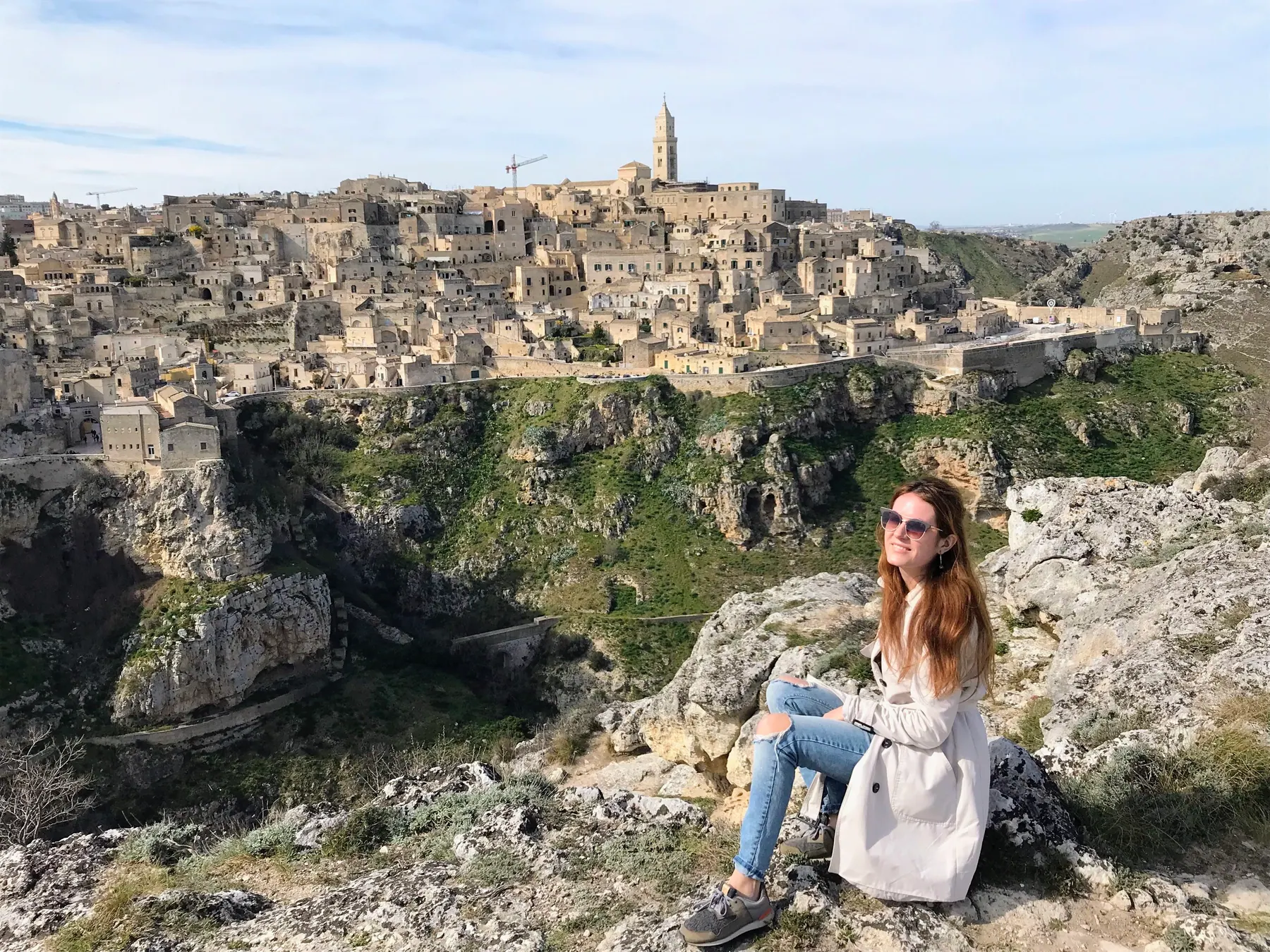 Una viajera entre las rocas de la Murgia con Matera al fondo