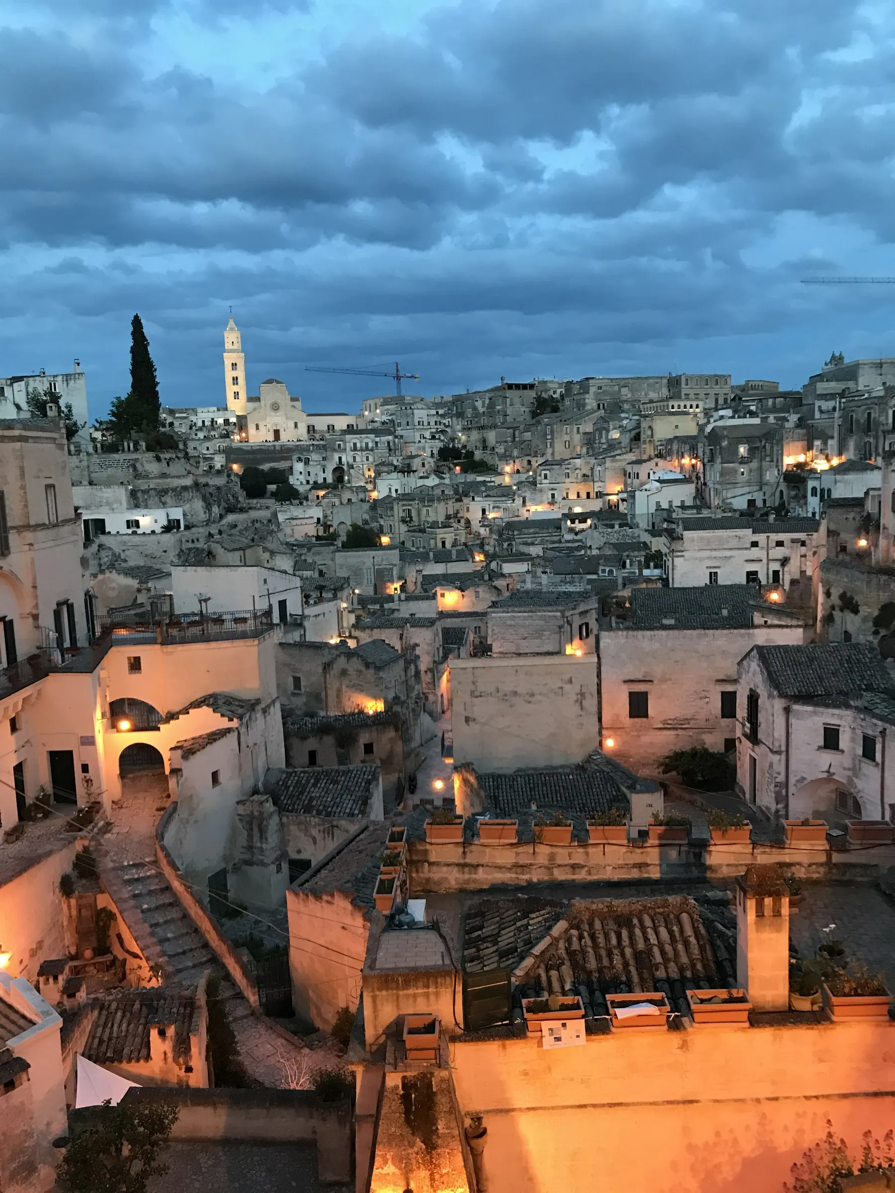 Los Sassi de Matera al anochecer bajo un cielo dramático