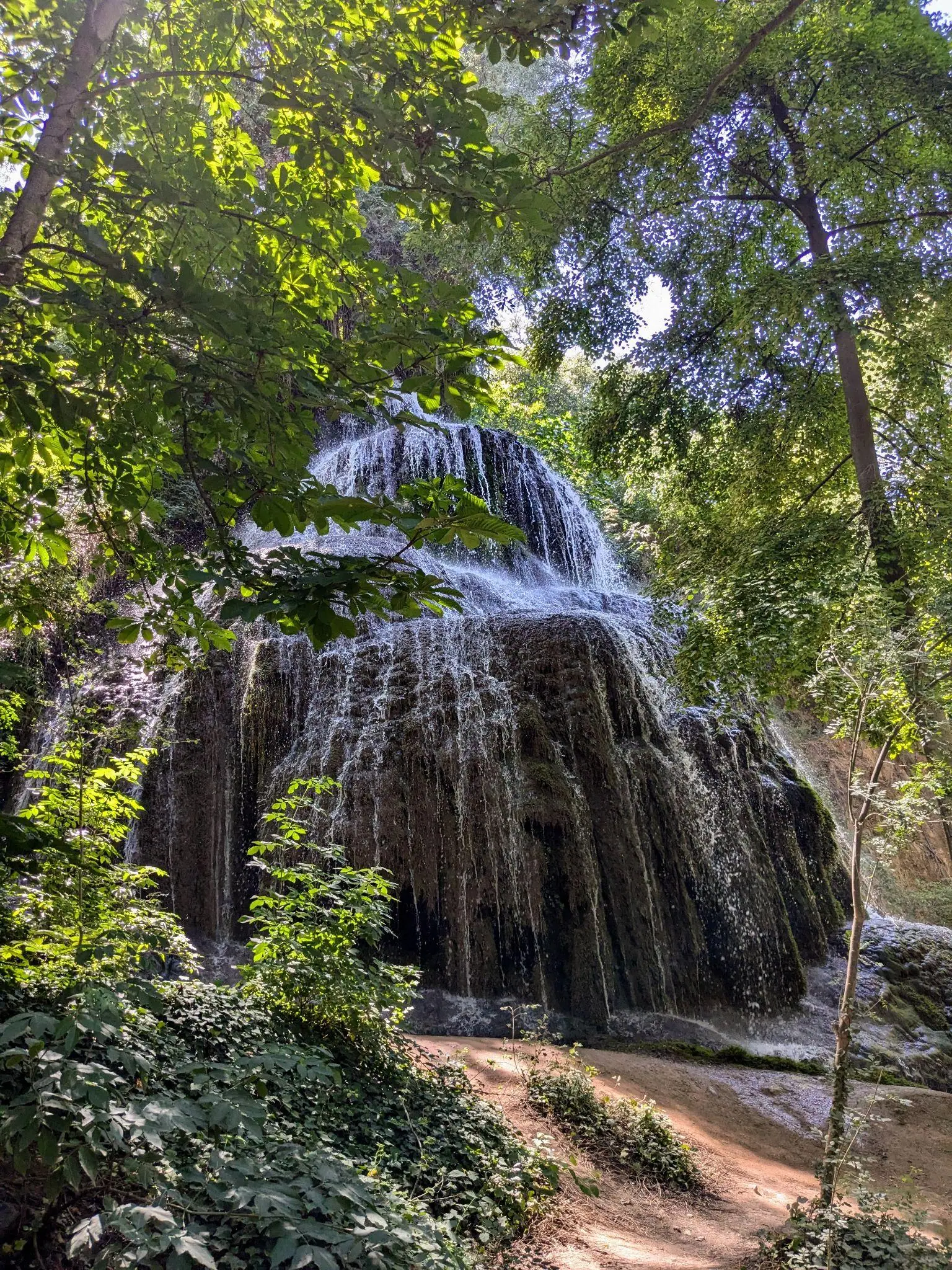 A wide waterfall surrounded by trees in Monasterio de Piedra