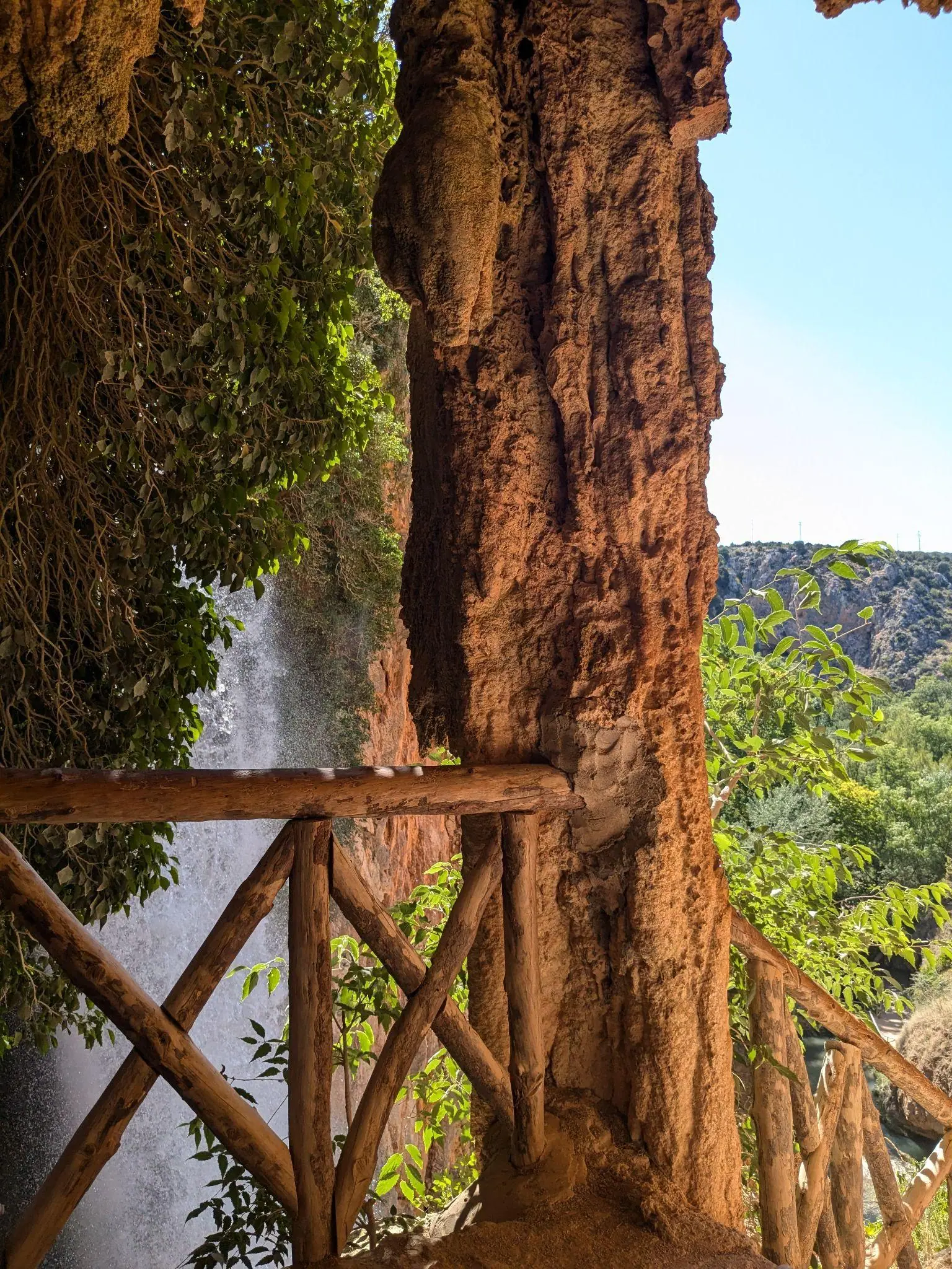 A wooden balcony path beside a waterfall at Monasterio de Piedra