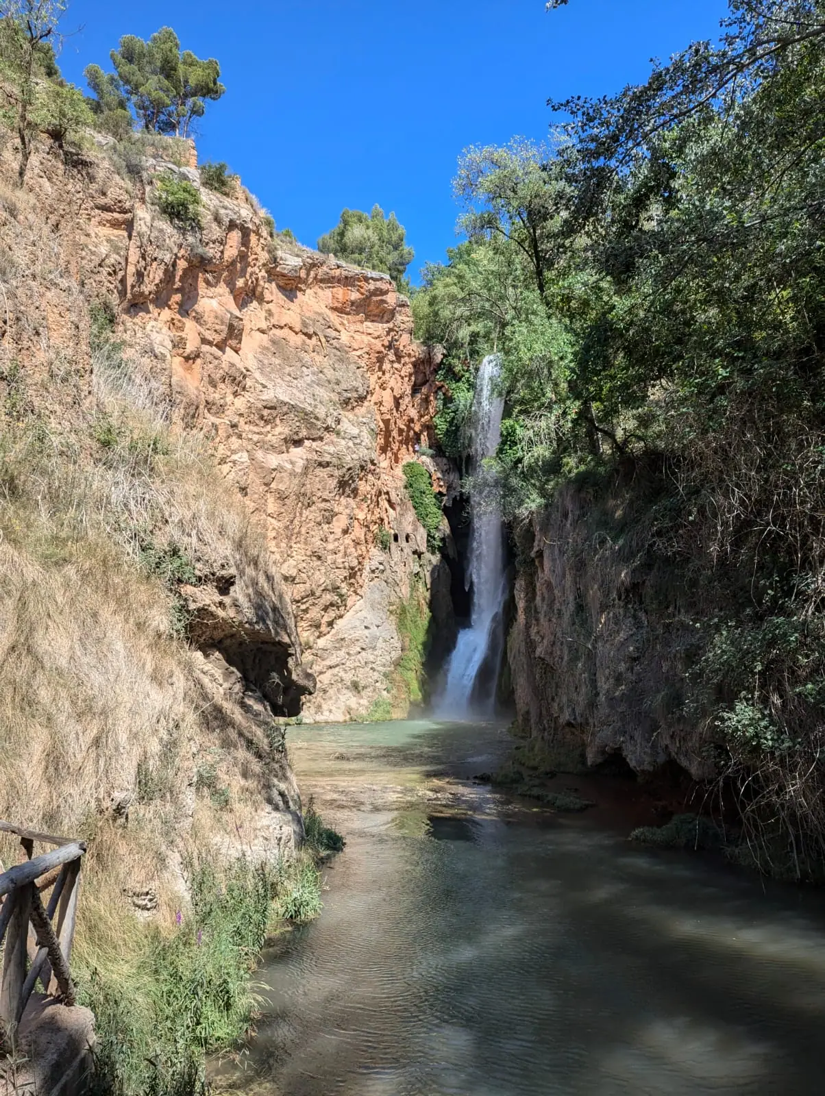 A waterfall dropping into a narrow canyon pool at Monasterio de Piedra