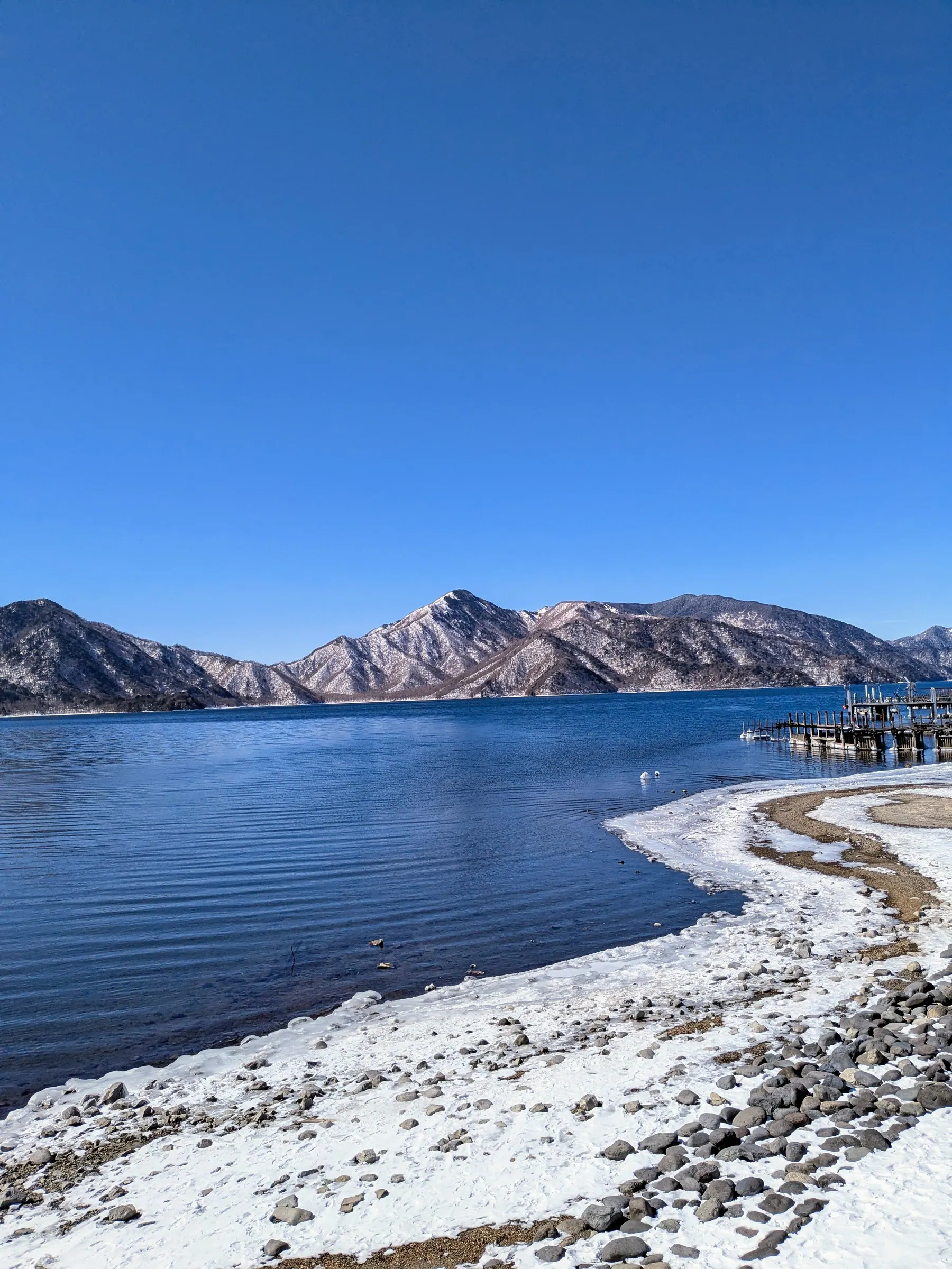 Snowy Lake Chūzenji with mountains in Nikko