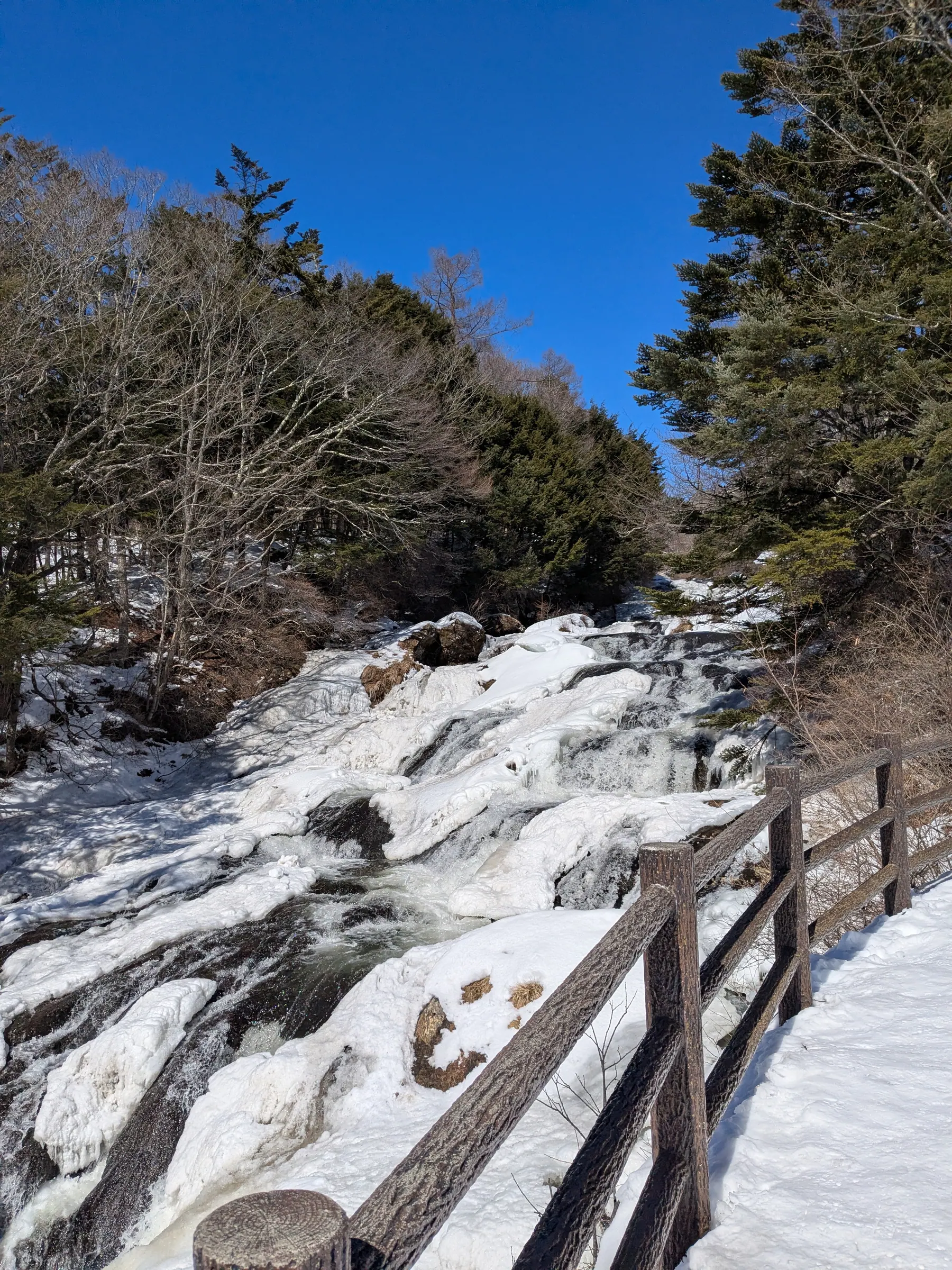 A snowy winter stream and walkway in Nikko