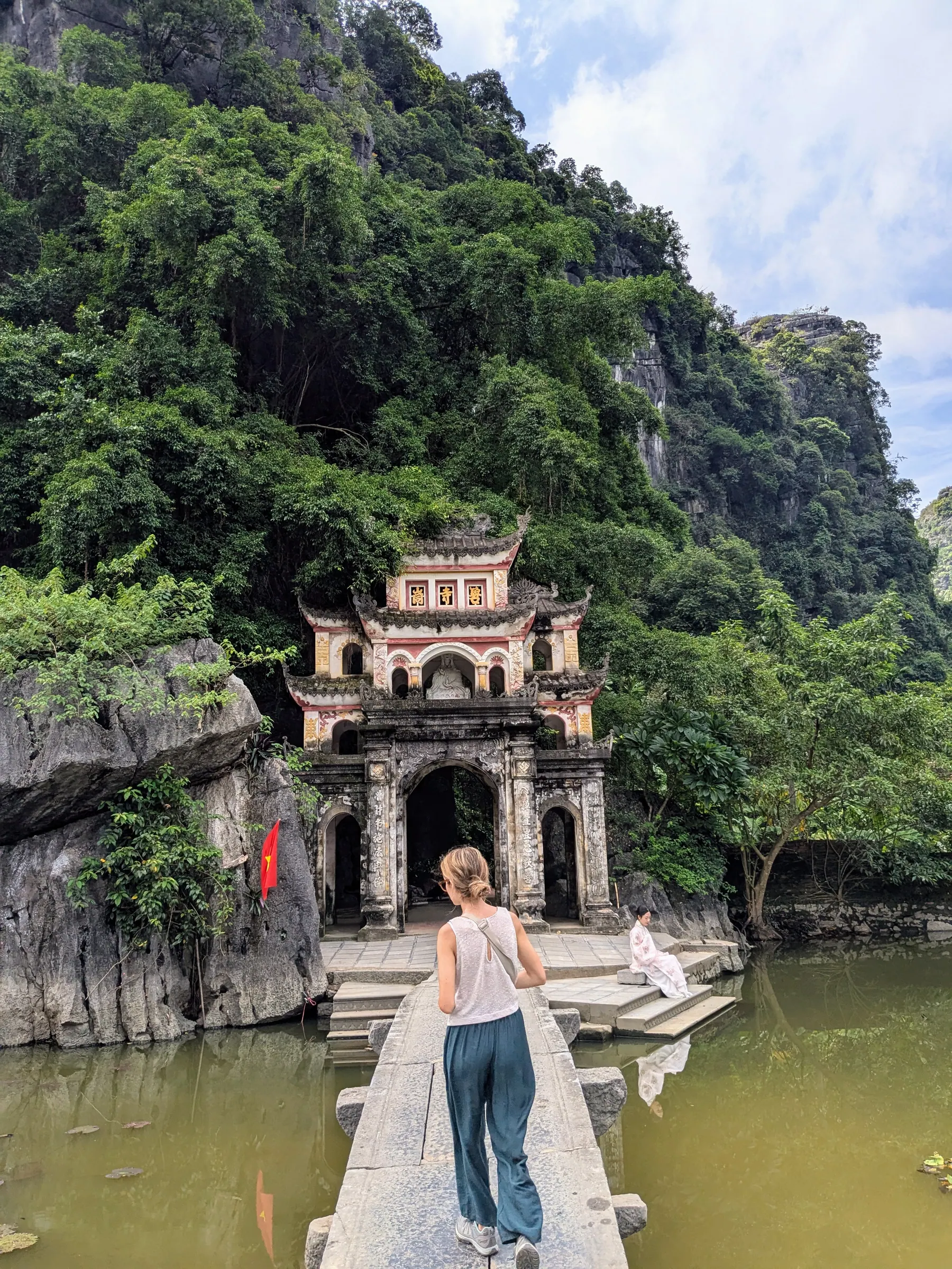 Zane standing before the stone entrance gate of Bich Dong Pagoda in Ninh Binh