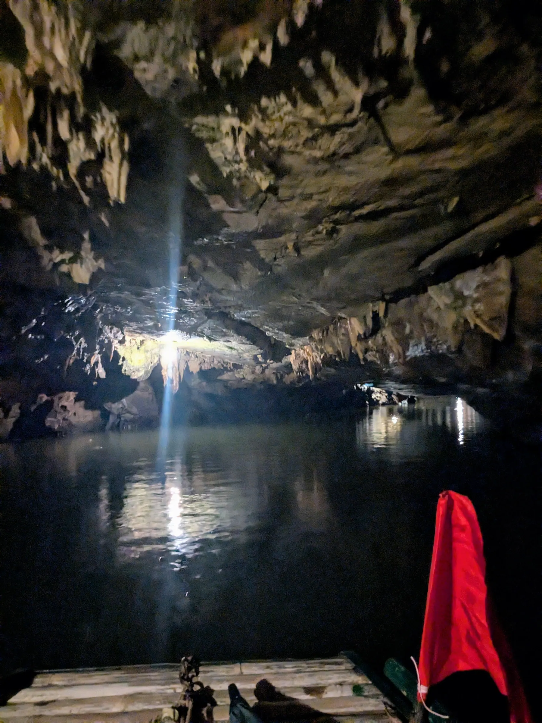 A boat moving through the dark Dot Cave at Trang An