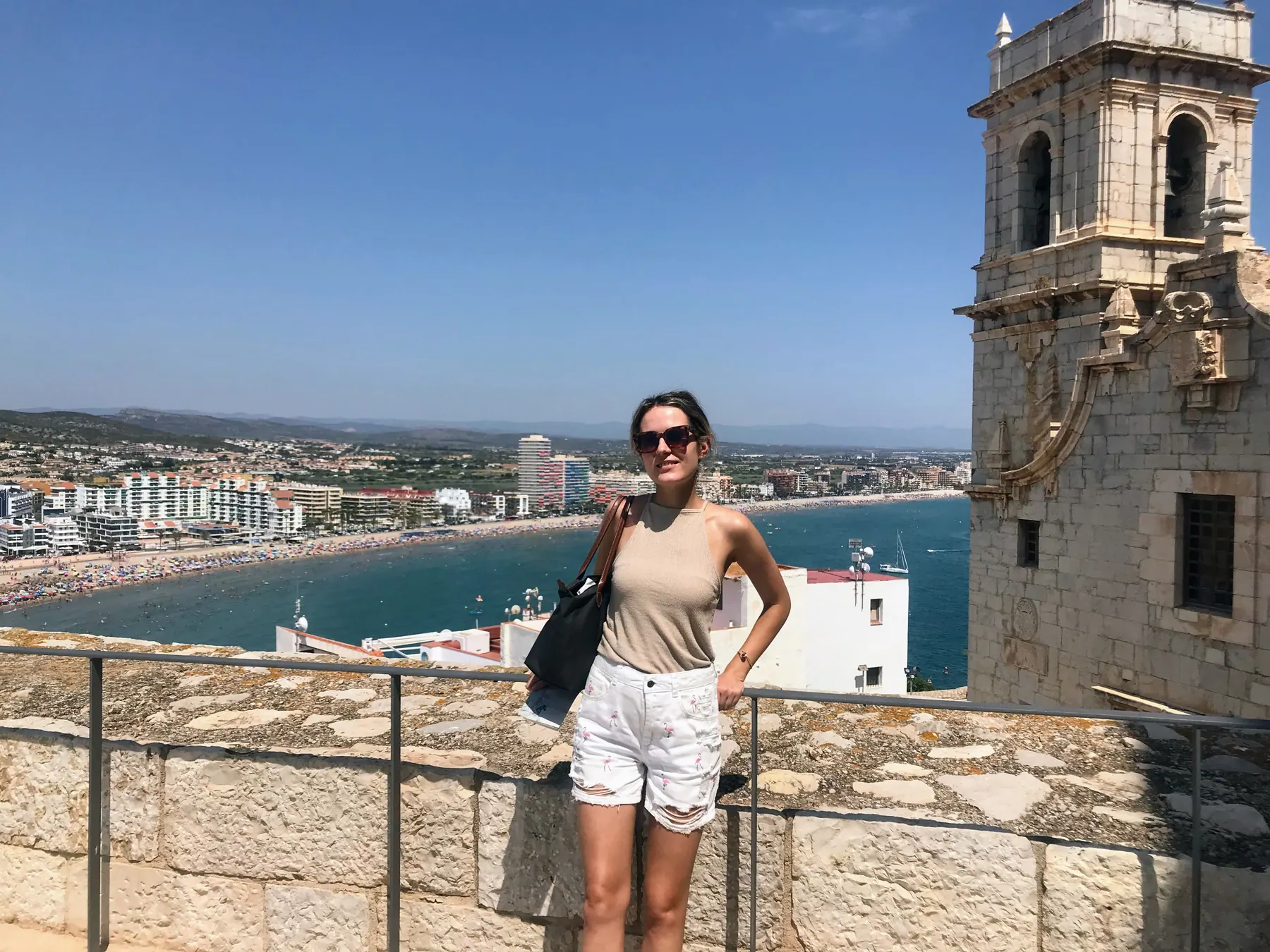 A traveler on the walls of Peñíscola Castle with Playa Norte behind her