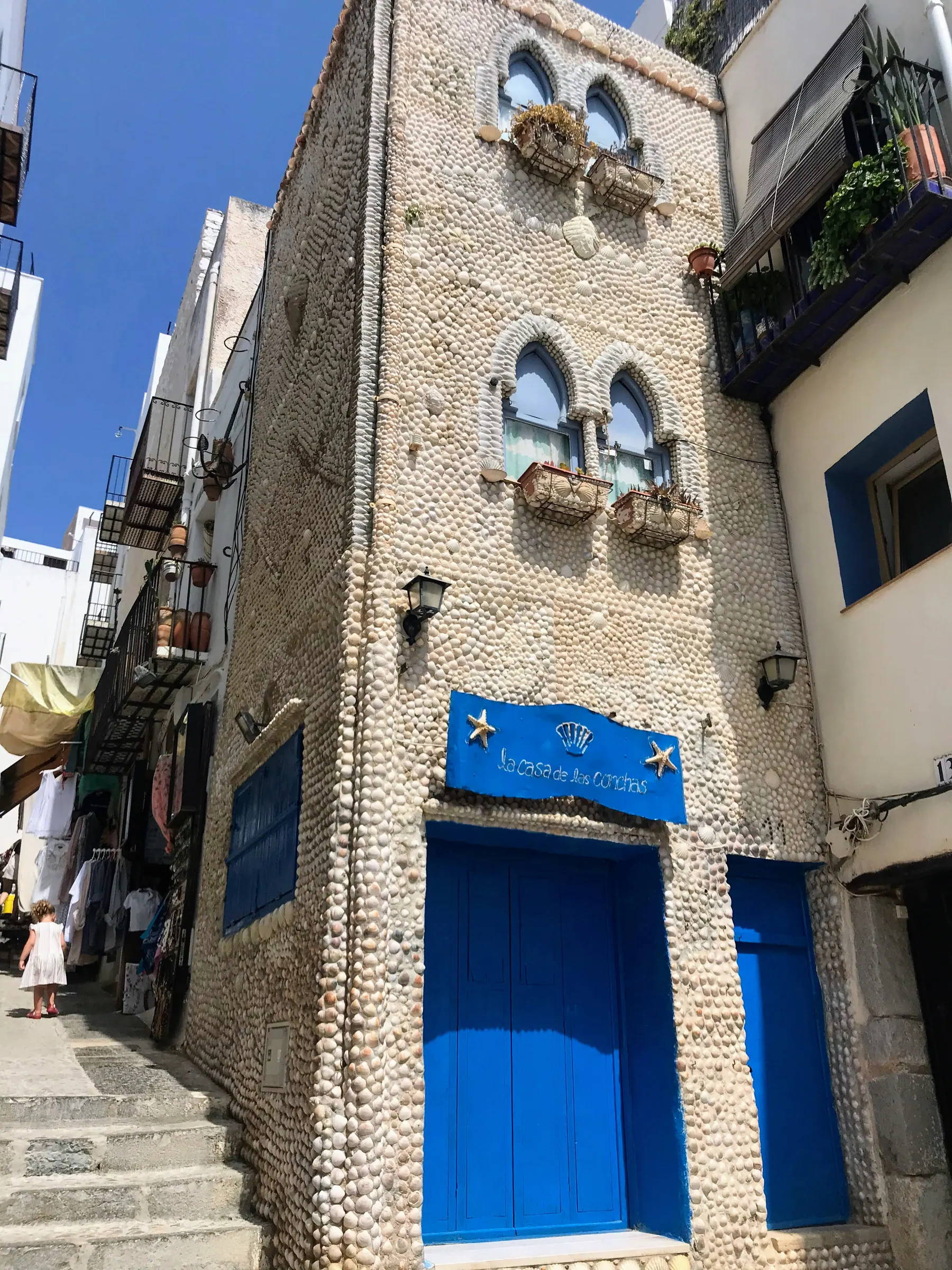 Shell-covered facade and blue doorway of Casa de las Conchas in Peñíscola
