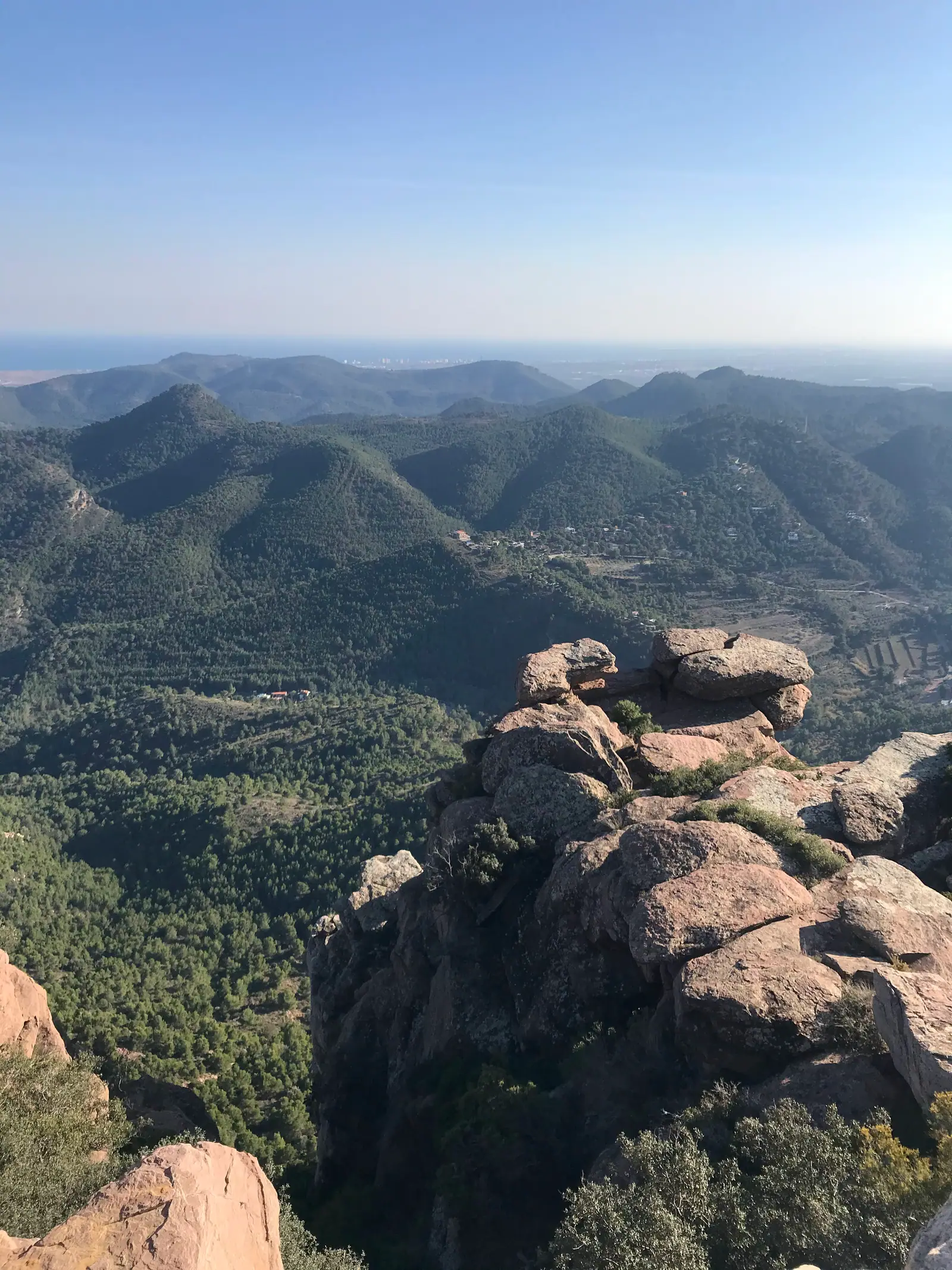 Formaciones de arenisca roja y crestas boscosas bajo el Mirador del Garbí