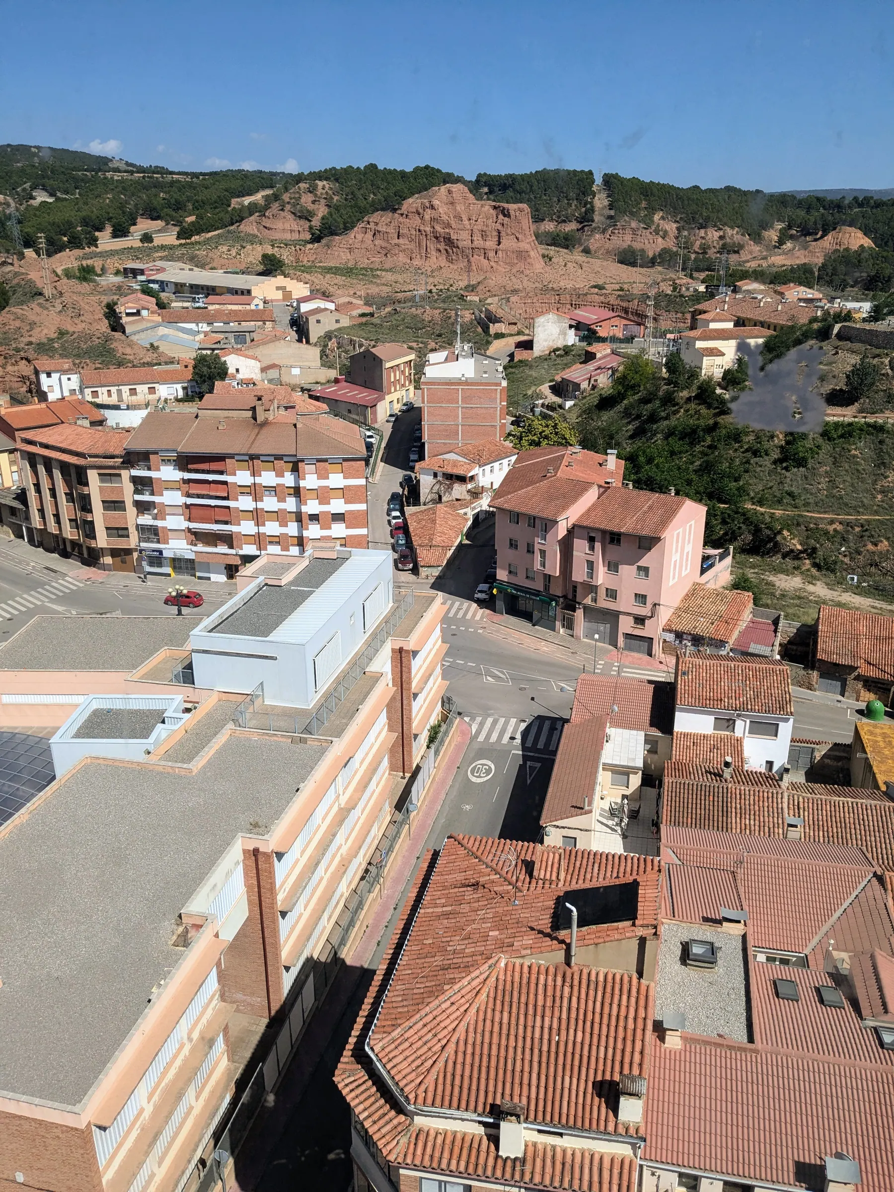 The rooftops of San Julián and pale clay hills seen from the lift viewpoint