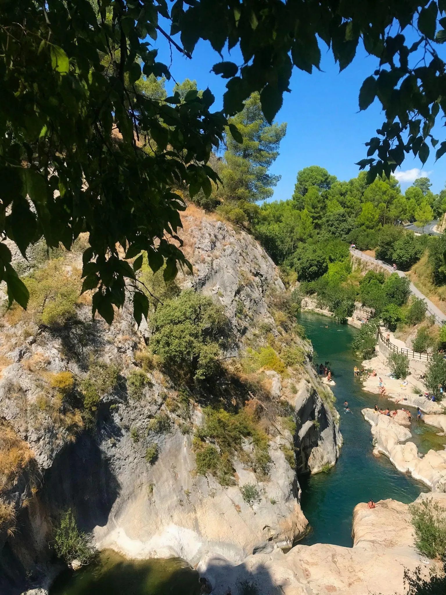 Clear turquoise river water flowing between smooth limestone rock pools at Pou Clar