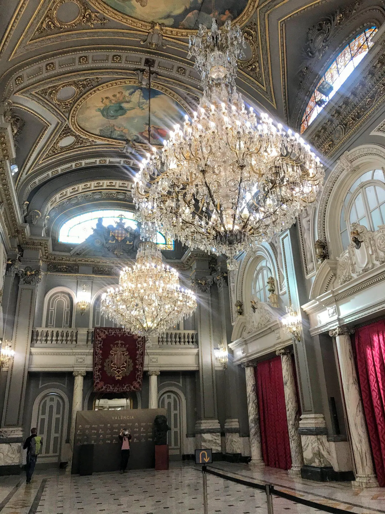 Escalera señorial de mármol y arcos de piedra en el interior del Ayuntamiento de Valencia