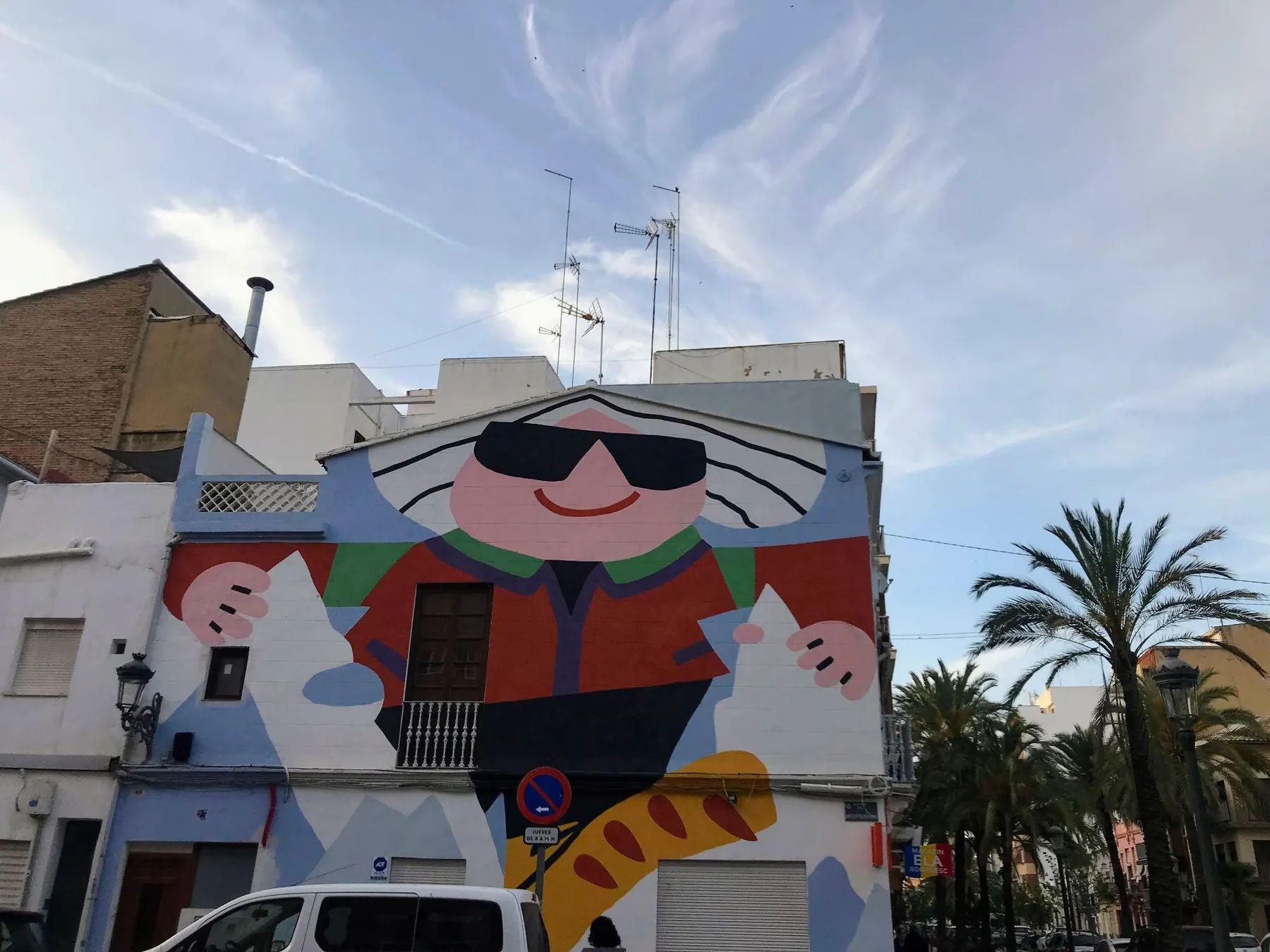 Calle residencial con fachadas de azulejos y colores vivos en El Cabanyal