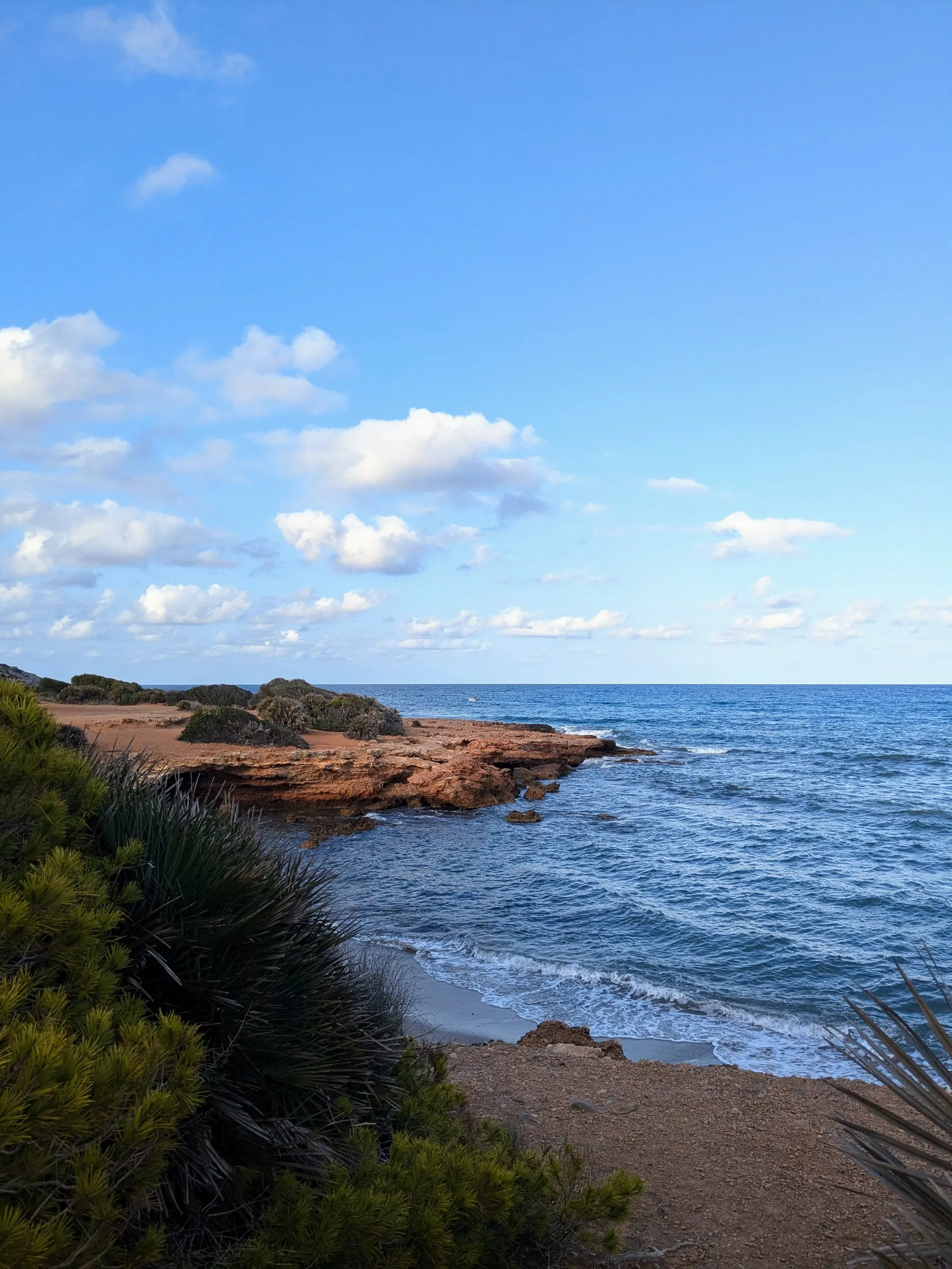 Rocky Mediterranean shoreline and low vegetation beside the Via Verde del Mar